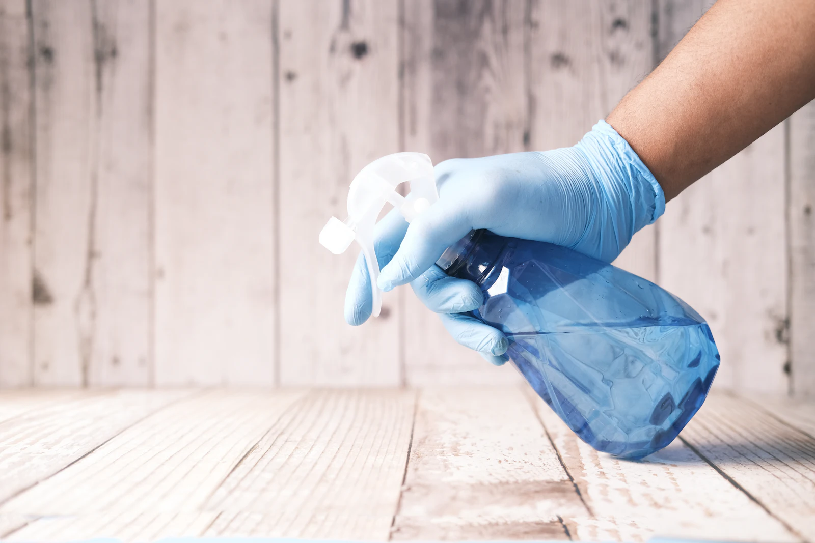 Cleaner spraying a surface with a spray bottle